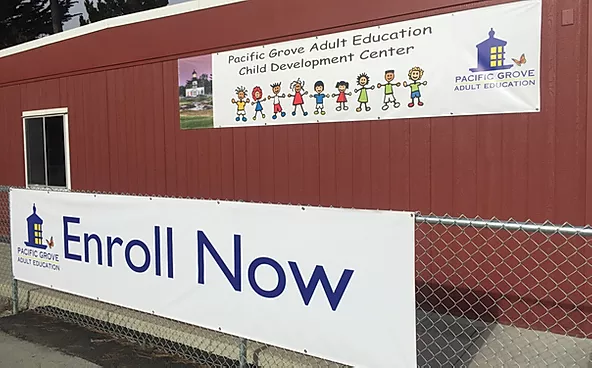 exterior view of building with sign reading enroll now